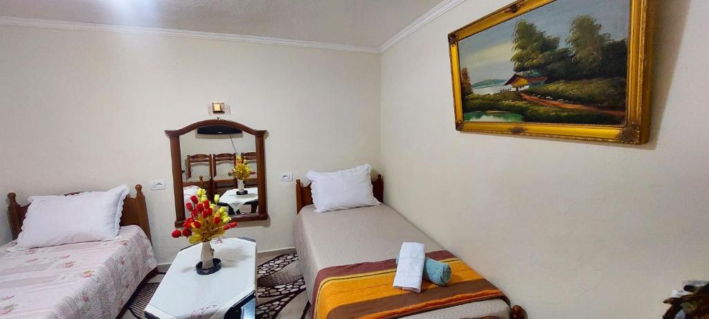 Una habitación con dos camas y un cuadro en la pared. en Shkodra Stay, en Shkodër