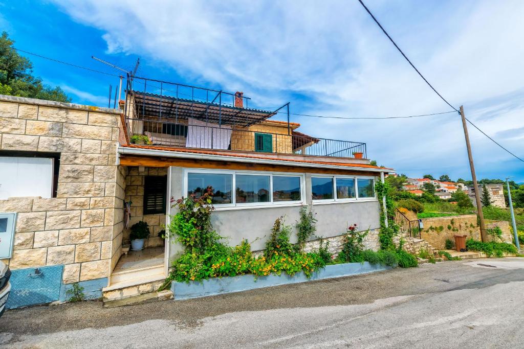 a house with a balcony on the side of it at Apartment New in Splitska