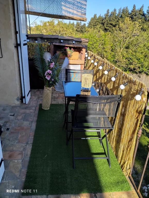 un patio avec une table et des chaises sur l'herbe dans l'établissement Maison de campagne en Provence, à Barbentane
