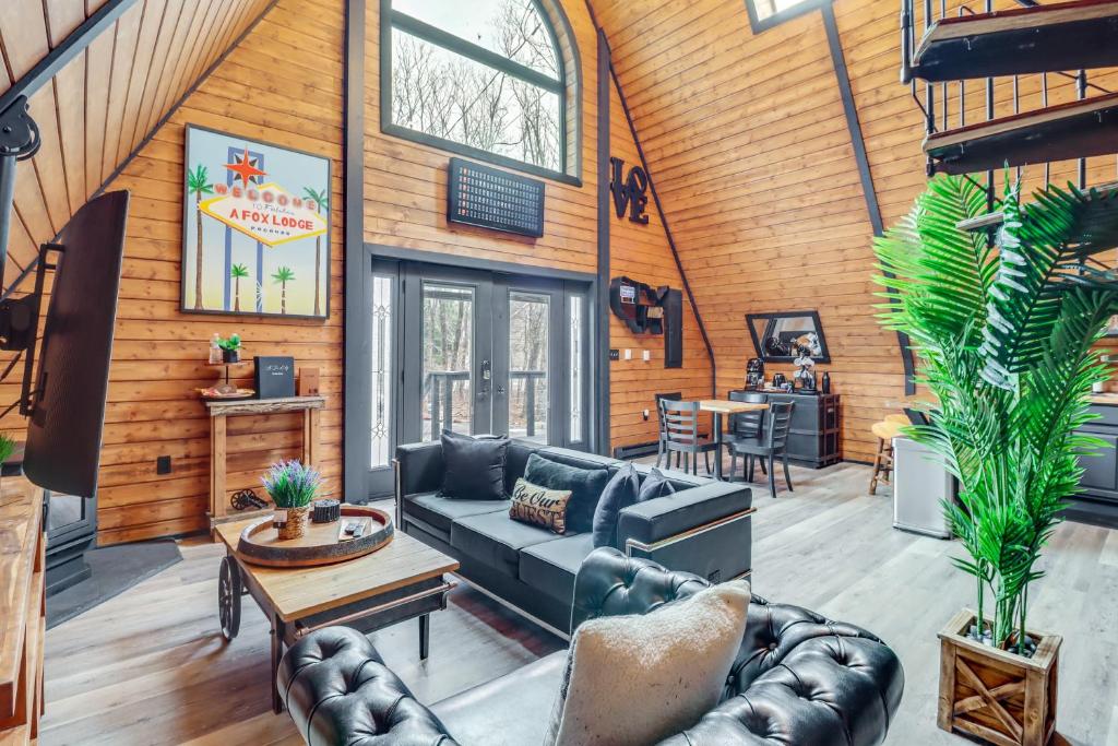 a living room with a couch and a table at 9 Mi to Big Boulder Mtn A-Frame Cabin with Hot Tub in Albrightsville