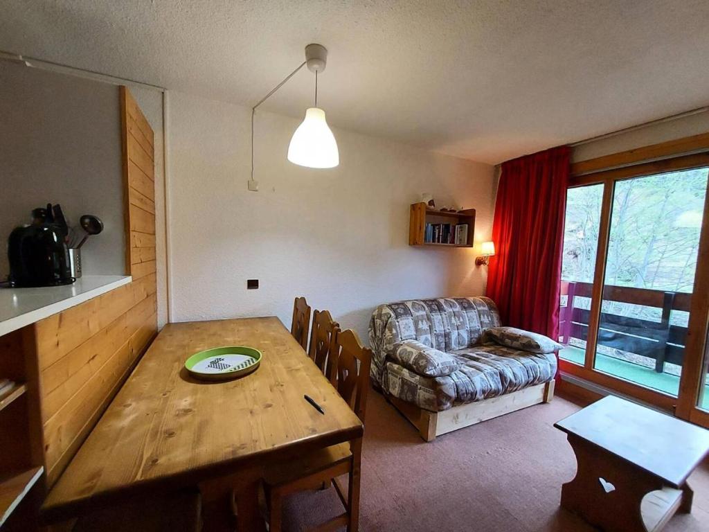 un salon avec une table en bois et un canapé dans l'établissement Résidence Cheval Noir G - CHEVAL NOIR 33 MAE-6401, à Valmorel