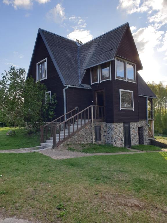a black house with a black roof at Semeniukų Sodyba in Rakantai
