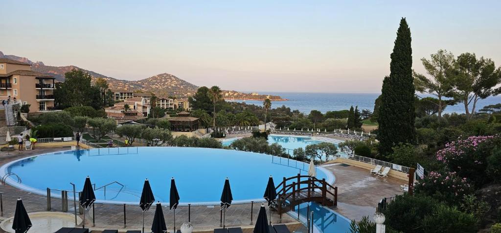 une grande piscine avec vue sur l'océan dans l'établissement T2 Vue mer, Jardin clos, Village vacances Cap Esterel St Raphaël, à Saint-Raphaël