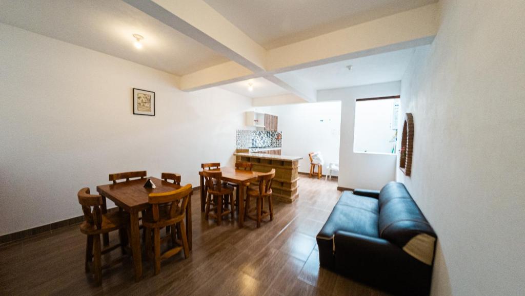 un soggiorno con un divano, un tavolo e delle sedie di ApartaHotel Margaritas de la Villa VDL a Villa de Leyva