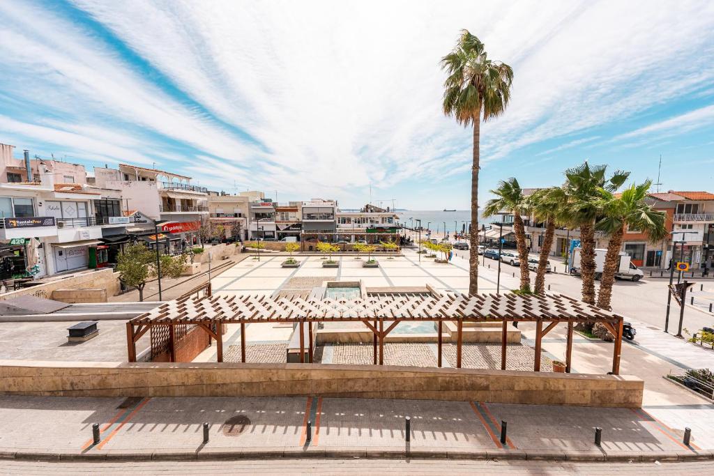 a park with a bench and palm trees in a city at SEA YOU SOON in Nea Moudania