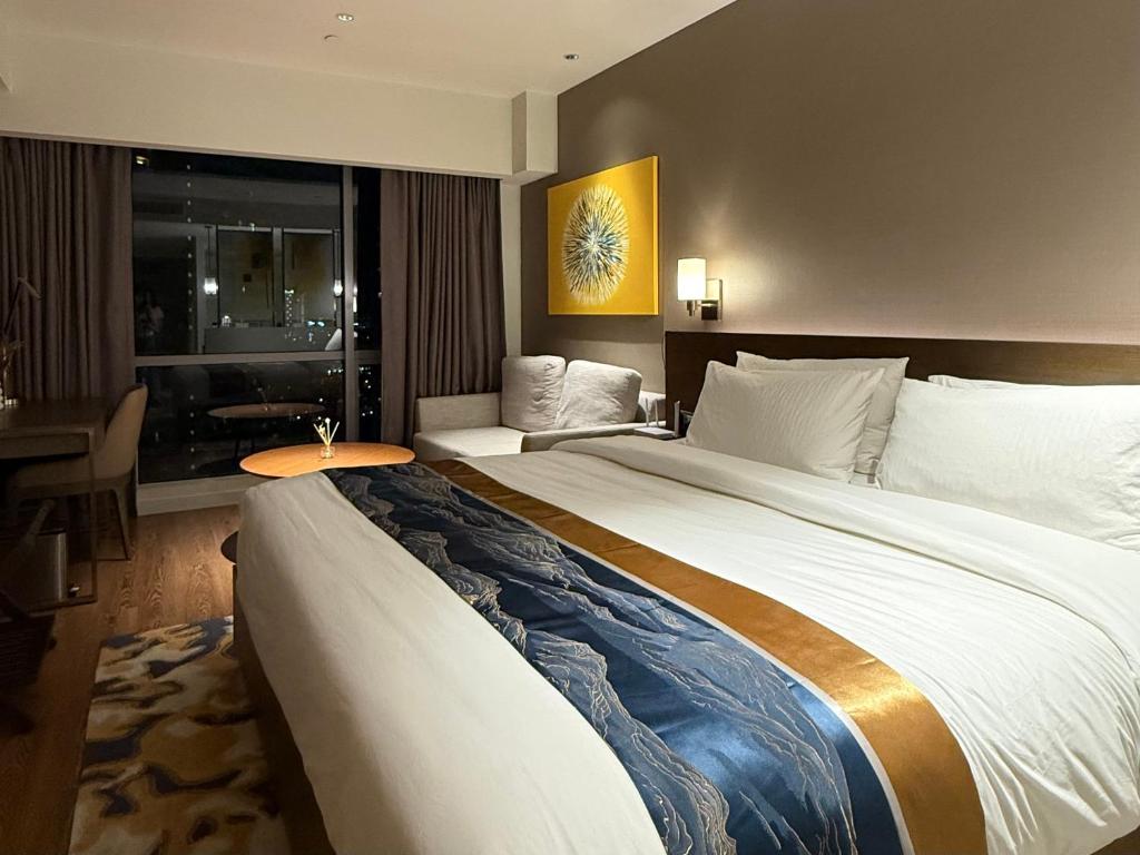 Postel nebo postele na pokoji v ubytování Novotel Suites Celestia at Hotel Residences Acqua Manila