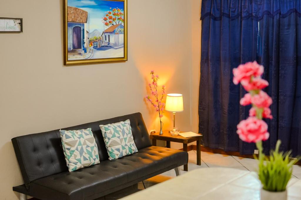 a living room with a black couch and a table at Apartamento completo Ideal para descansar en familia en San Salvador in San Salvador