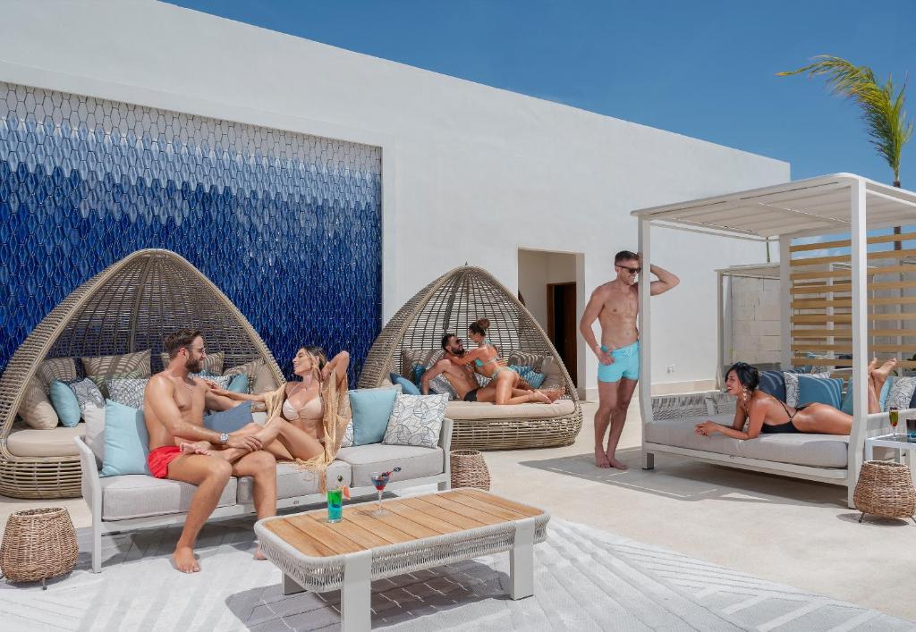 a rendering of a pool with people sitting in wicker chairs at Desire Riviera Maya Resort All Inclusive - Couples Only in Puerto Morelos