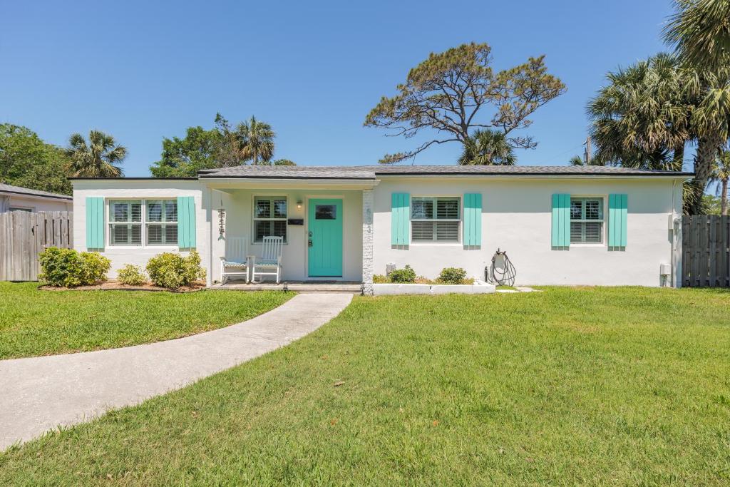 a house with a green door and a yard at Be A Nomad - Breezy 4BR Escape Near Jax Beach in Jacksonville Beach