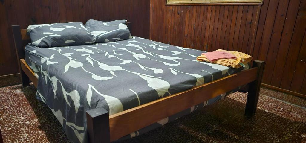 Una cama con un edredón azul y blanco. en Hospedaje24hs, en Argentina