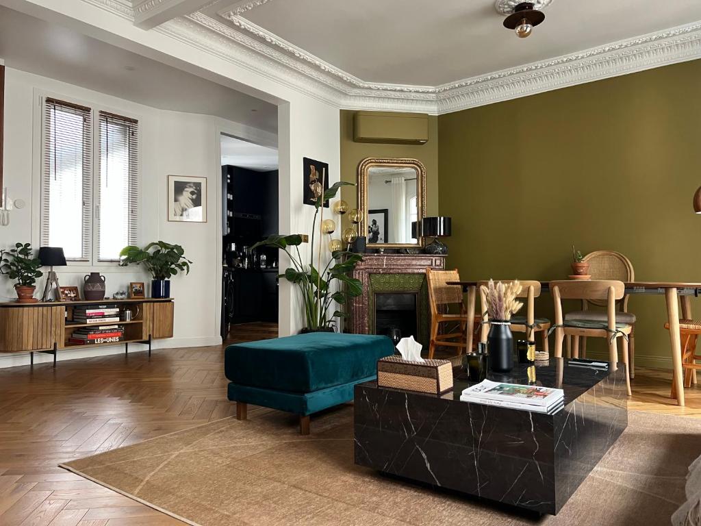 un salon avec un canapé et une cheminée dans l'établissement Bel appartement Paris Montmartre, à Paris