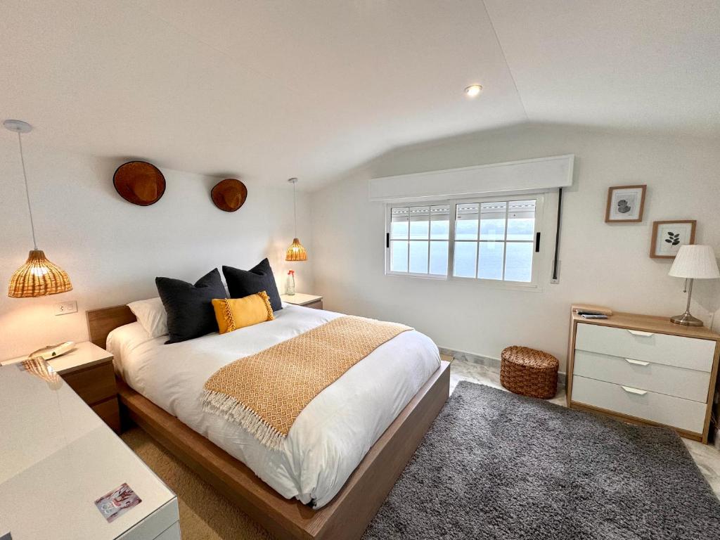 a bedroom with a large bed and a window at Casa A Codela in Combarro