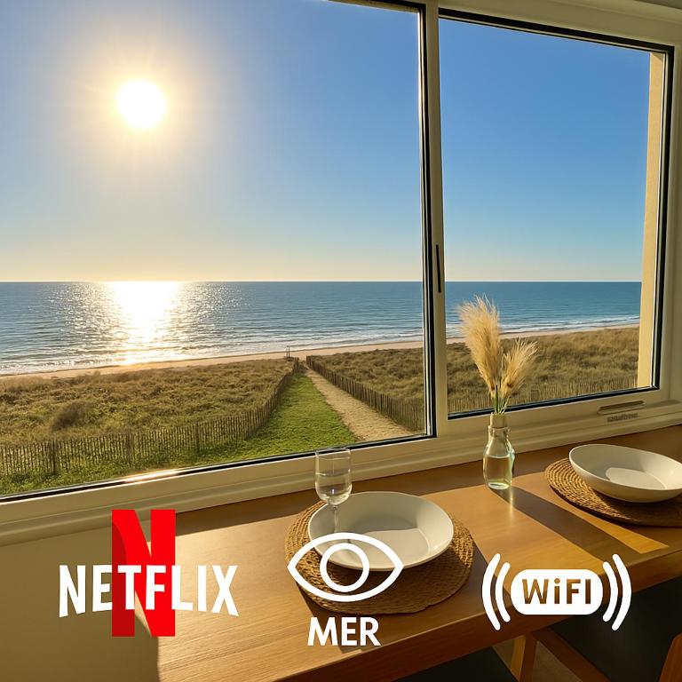 - une table avec vue sur l'océan depuis une fenêtre dans l'établissement L'eden plage, à Saint-Hilaire-de-Riez