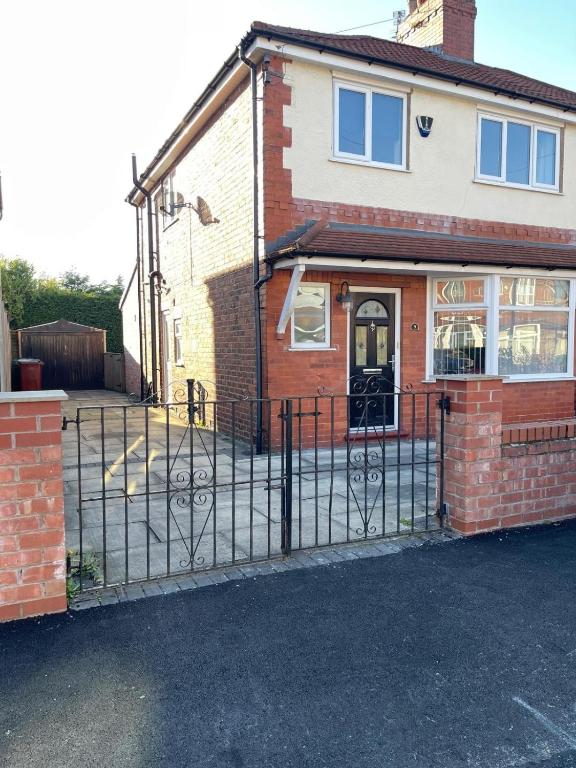 a house with a wrought iron gate in front of it at Spacious 3 bed with driveway in Manchester