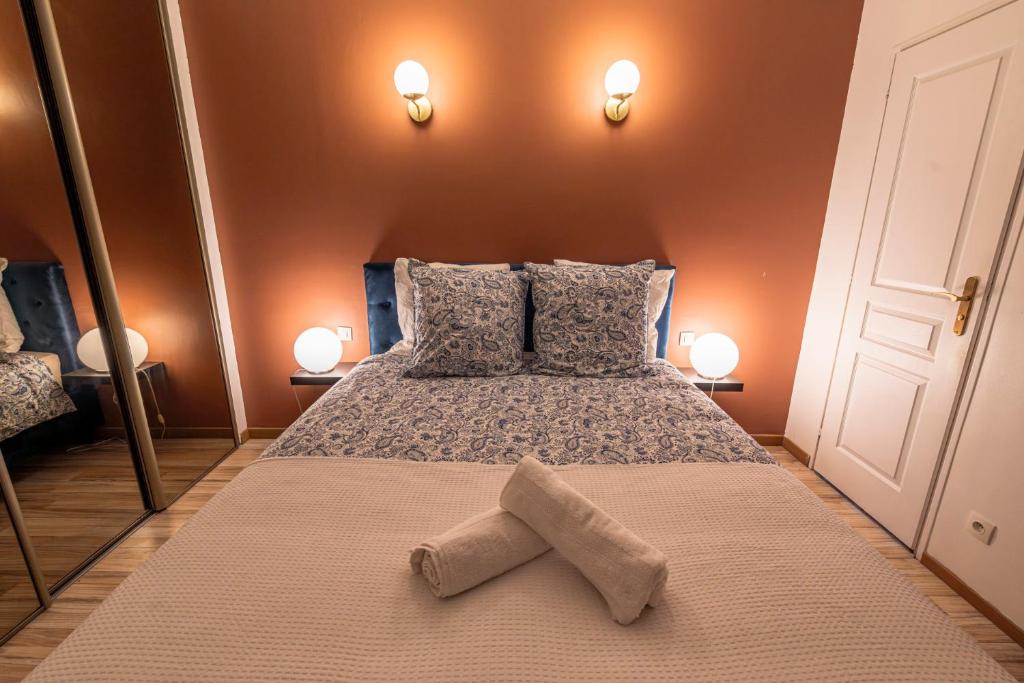 une chambre avec un grand lit avec deux oreillers dans l'établissement Le 1er Général - Center - Free Park, à Reims