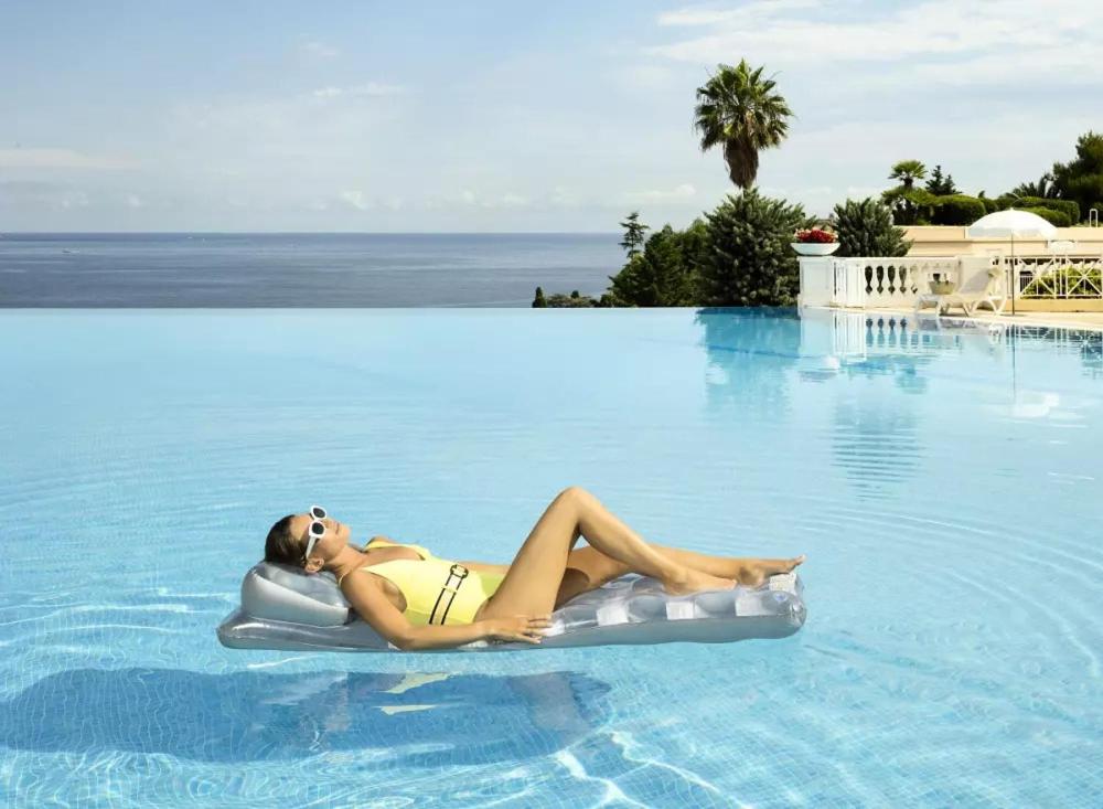 une femme qui se pose sur un radeau dans une piscine dans l'établissement Holiday Paradise, à Cannes