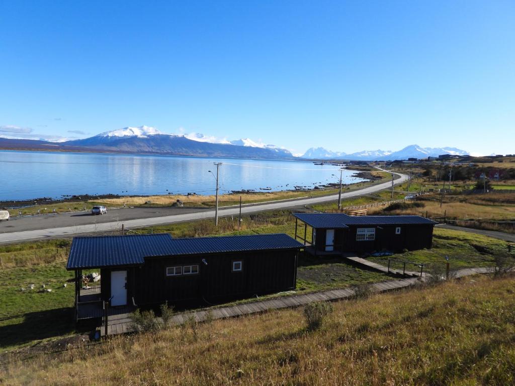 a view of two cabins on the side of a lake at Cabañas AlSur Patagonia in Puerto Natales