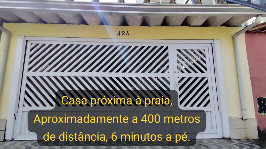 a garage door with a sign on it at Casa Amarelinha da Tupi in Praia Grande