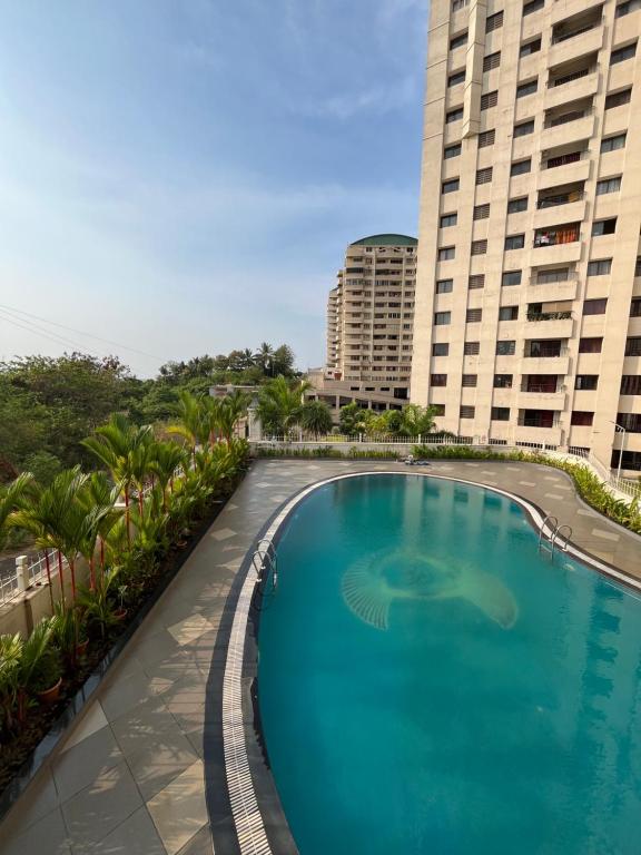 a large swimming pool in front of two tall buildings at Flat in Manipal cozy corner in Manipala