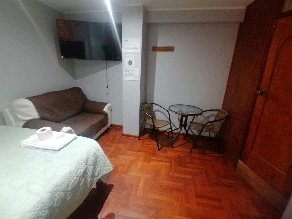 a room with a bed and a couch and a table at Hospedaje San Blas in San Antonio