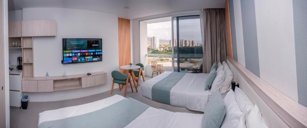 a hotel room with a bed and a desk and a window at Porto Horizonte Suite 735 in Santa Marta