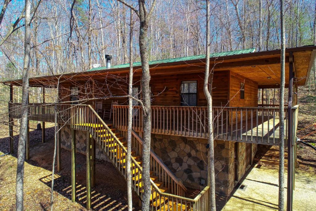 a log cabin in the woods with stairs leading up to it at Into the Wild in Cosby