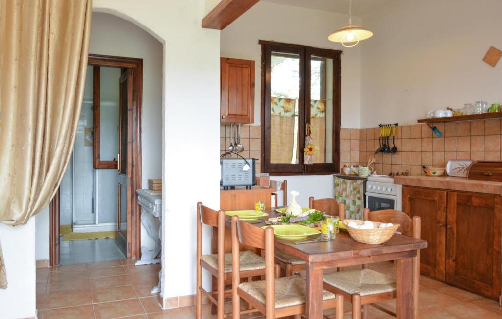kuchnia z drewnianym stołem i krzesłami w obiekcie Cozy Home In Sedini With Wifi w mieście Sedini