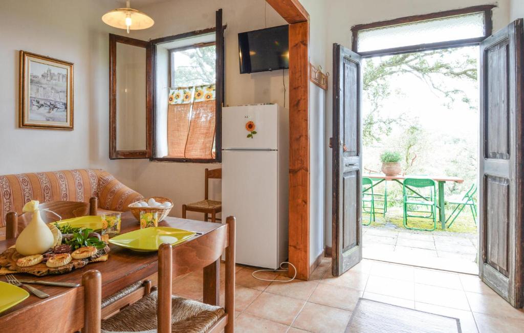 kuchnia i jadalnia ze stołem i lodówką w obiekcie Cozy Home In Sedini With Wifi w mieście Sedini