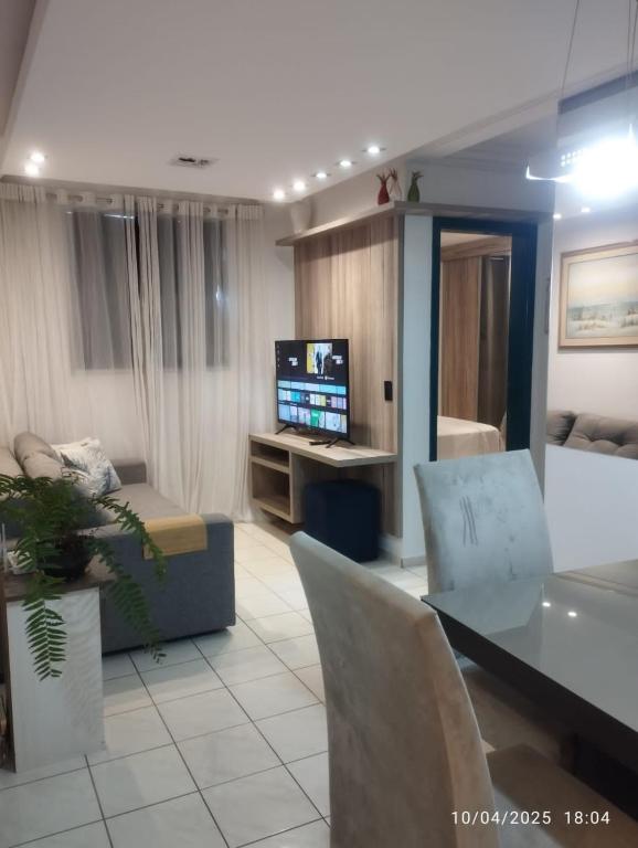 a living room with a table and chairs and a television at Mi casa su casa 3 in Londrina