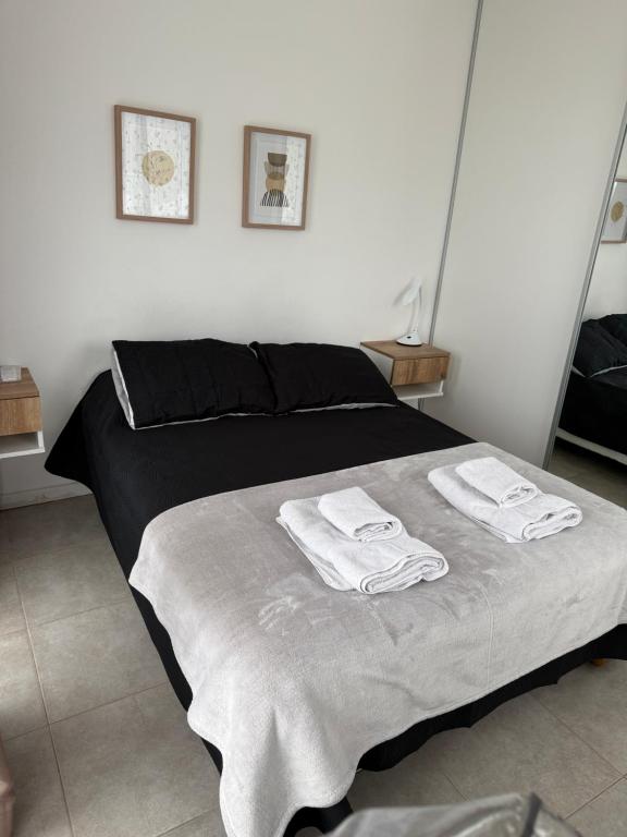 a bedroom with a bed with towels on it at Patagonia Alamos II in Comodoro Rivadavia