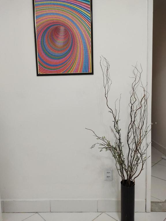 a black vase with a colorful painting on a wall at Casa Florescer in Salvador