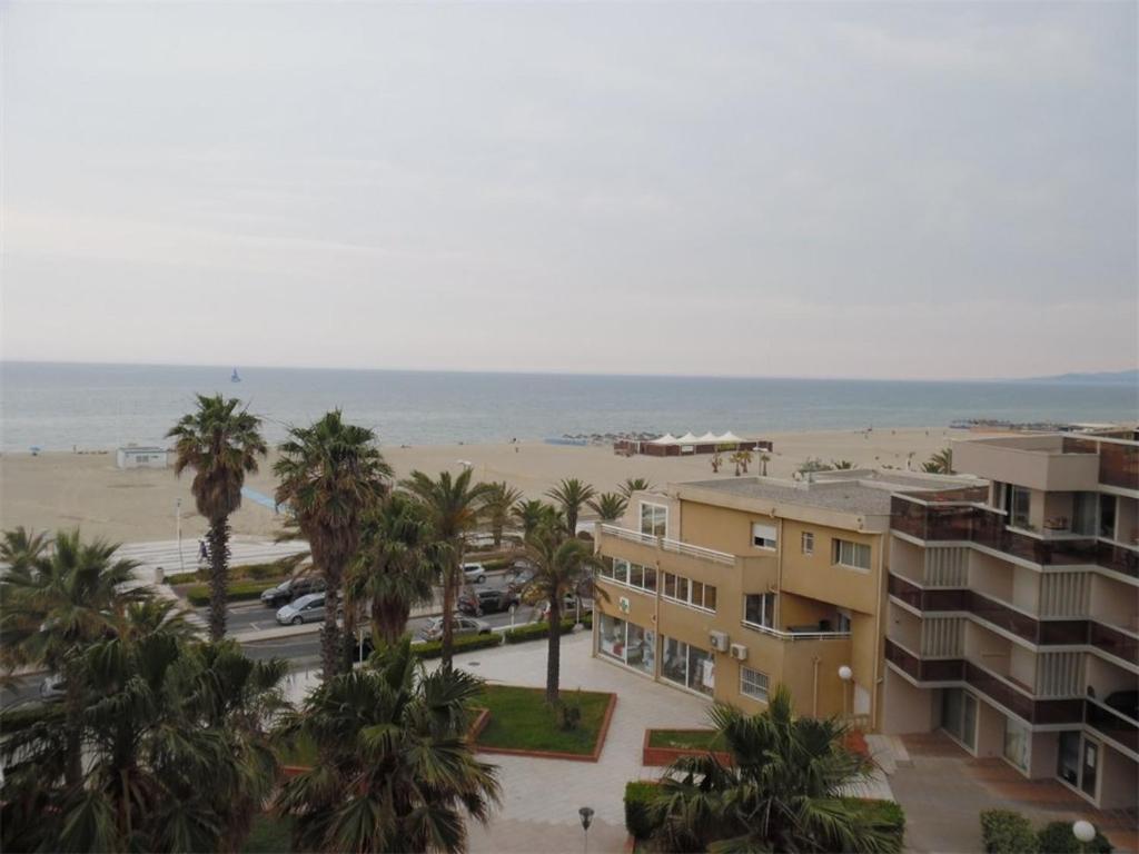 une vue sur la plage depuis le balcon d'un immeuble dans l'établissement Deux-Pièces Vue Mer avec Parking à Canet-Plage - FR-1-750-72, à Canet