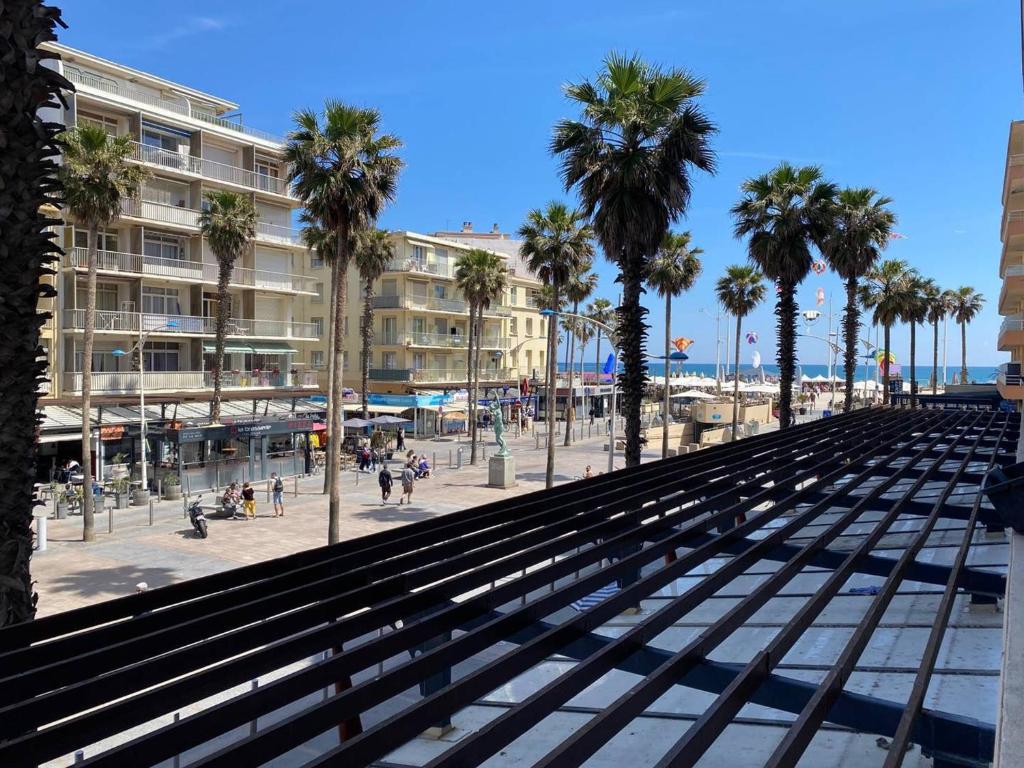 - une vue sur une plage bordée de palmiers et de bâtiments dans l'établissement Studio central avec loggia et wifi - FR-1-833-21, à Canet
