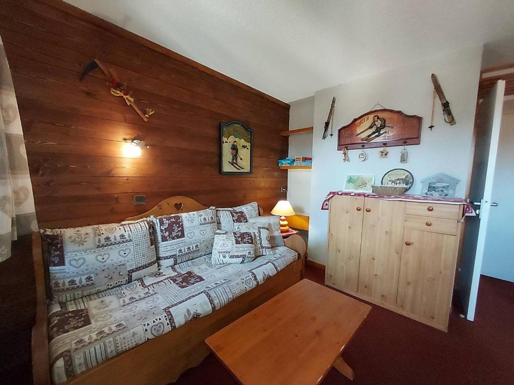 une chambre avec un lit et un mur en bois dans l'établissement Studio divisible sur piste à Valmorel, proche commodités - FR-1-356-535, à Valmorel