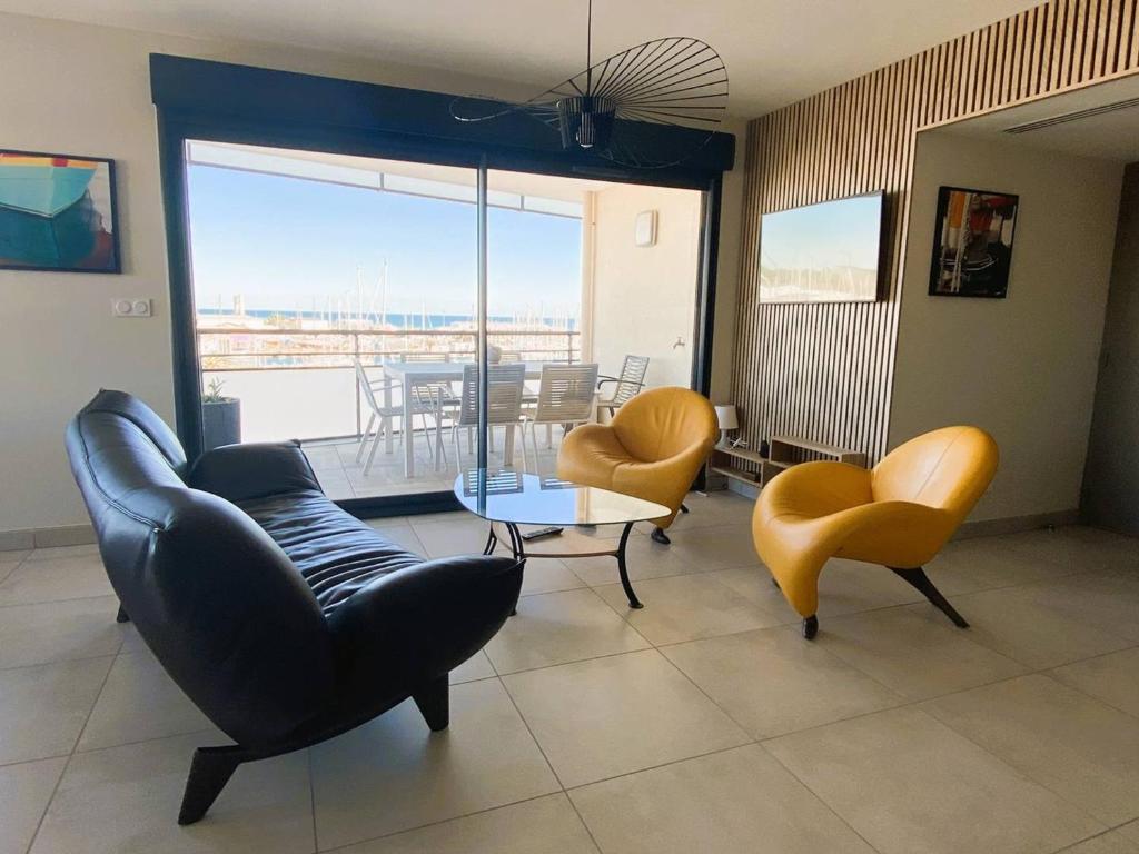 d'un salon avec des chaises et une table ainsi que d'un balcon. dans l'établissement Appartement de luxe 4 étoiles avec climatisation et parking à Canet-Plage - FR-1-750-74, à Canet