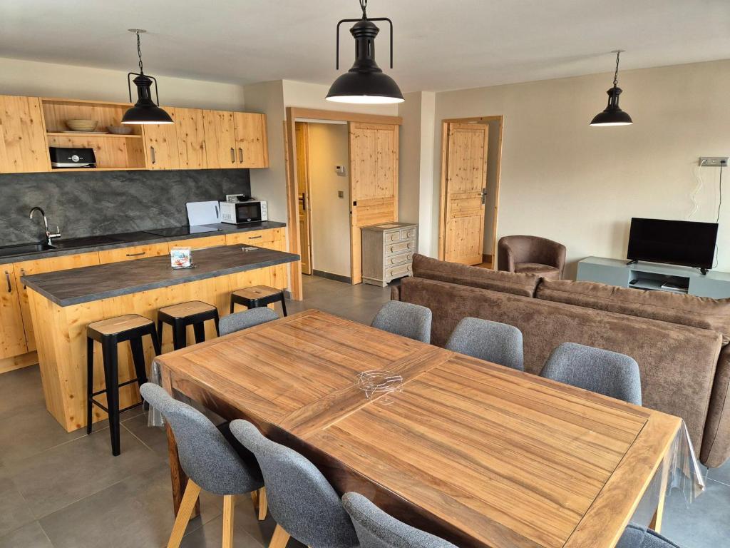 une cuisine et une salle à manger avec une table et des chaises en bois dans l'établissement Appartement lumineux, neuf, à 250m des pistes, animaux admis - FR-1-811-14, à Les Deux Alpes