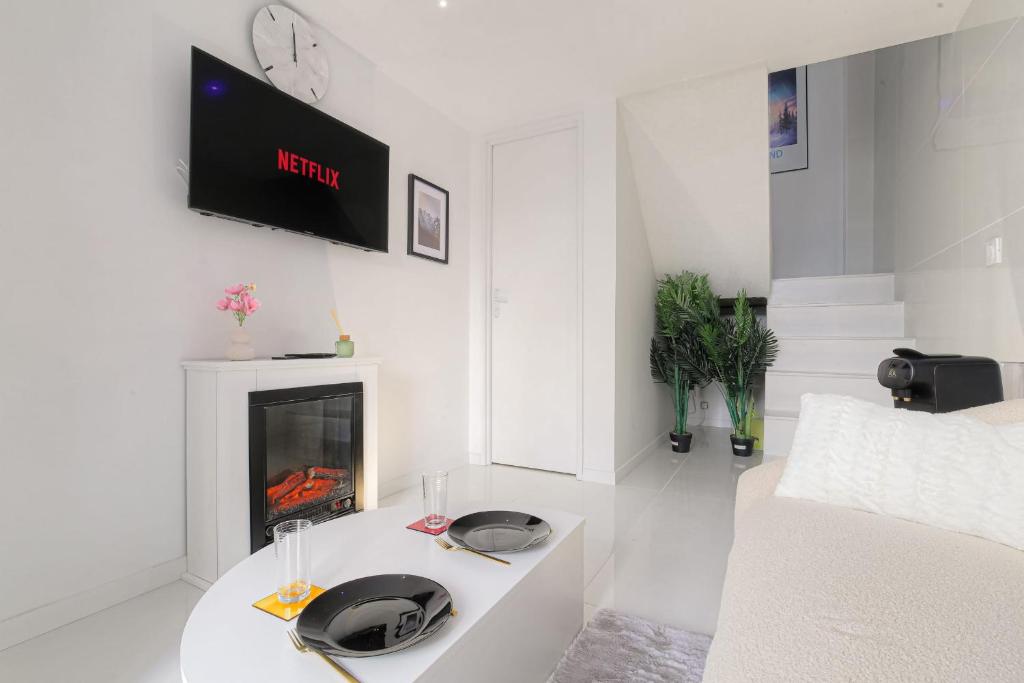 Il comprend un salon blanc doté d'une cheminée et d'une télévision. dans l'établissement Cosy et Chaleureux duplex Brotteaux - Masséna, à Lyon
