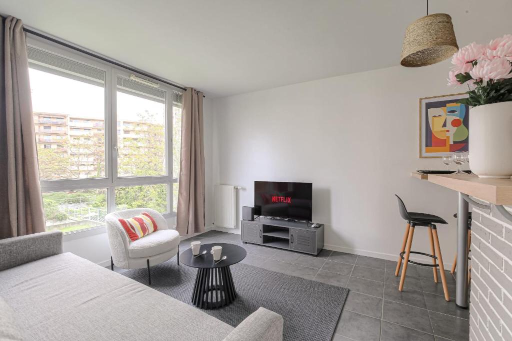 un salon avec un canapé et une télévision dans l'établissement Cosy et Calme 7min métro Garibaldi, à Lyon