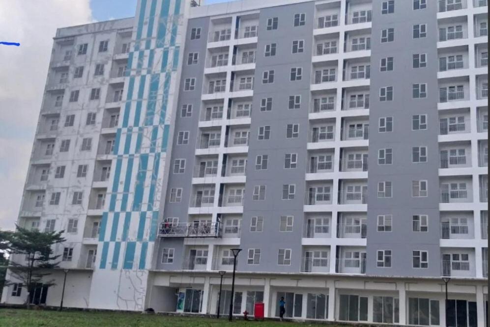 a large gray apartment building with blue windows at Apartemen 2BR dekat Jakabaring Sport Center & Opi Mall in Baguskuning