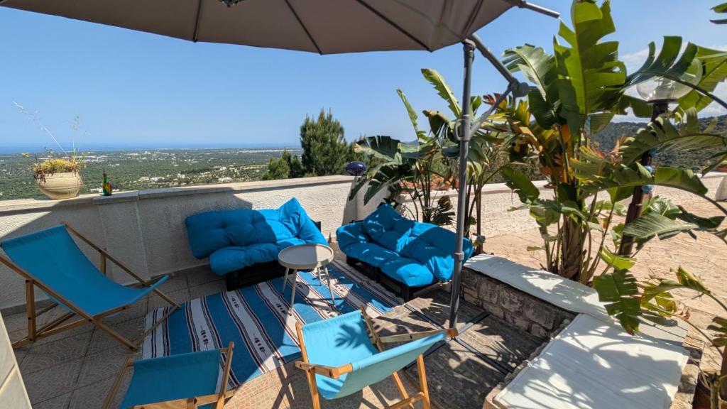 a group of chairs and an umbrella on a patio at Bellavista in Selva di Fasano