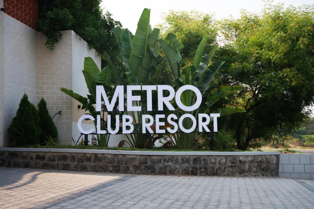 a sign for a micro club resort on a building at Metro Club Resort in Kāmānayakkanpālaiyam