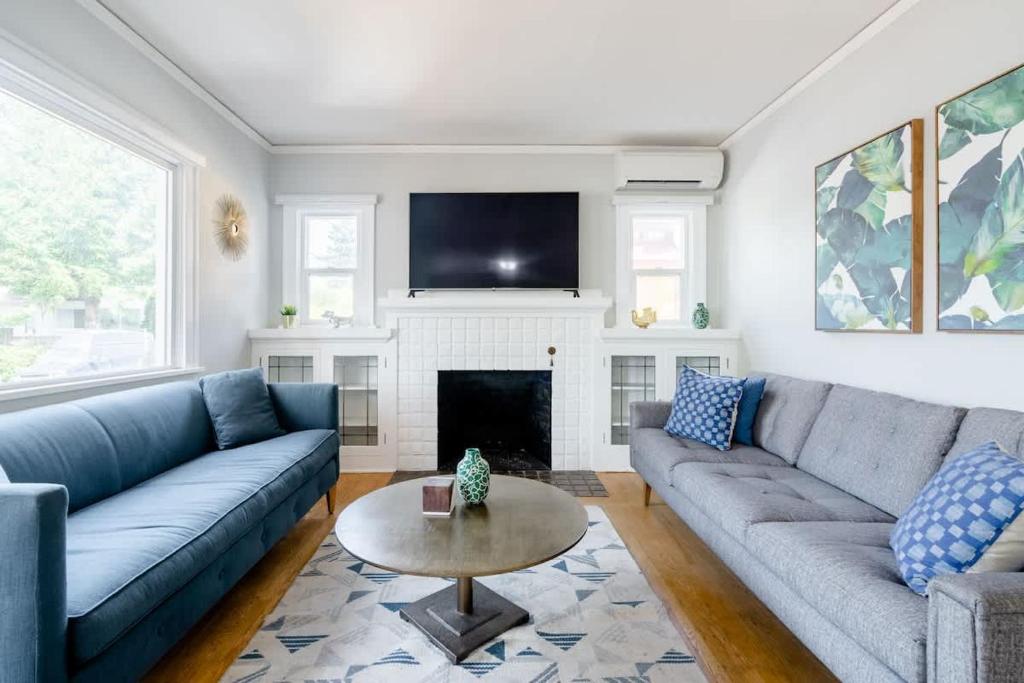 ein Wohnzimmer mit blauen Sofas und einem Kamin in der Unterkunft Stay Portland - Classic 1920s Alberta Four Bedroom Haven in Portland