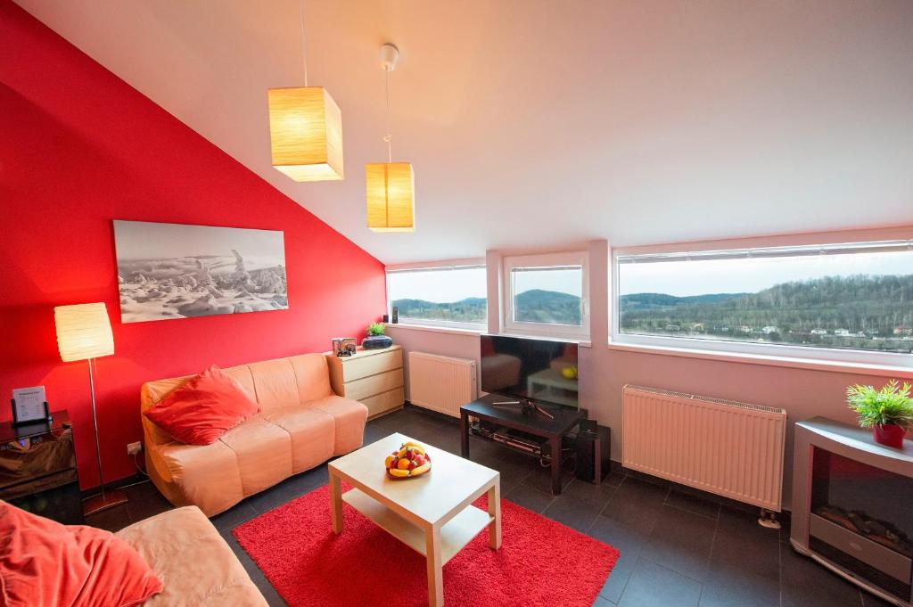 uma sala de estar com uma parede vermelha em Apartma Panorama Jeseník em Jeseník