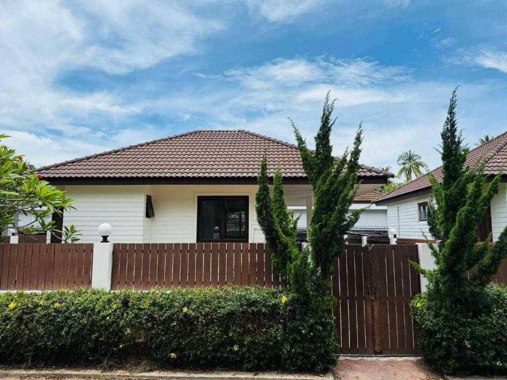 a white house with a wooden fence at Simply Homes in Koh Samui 