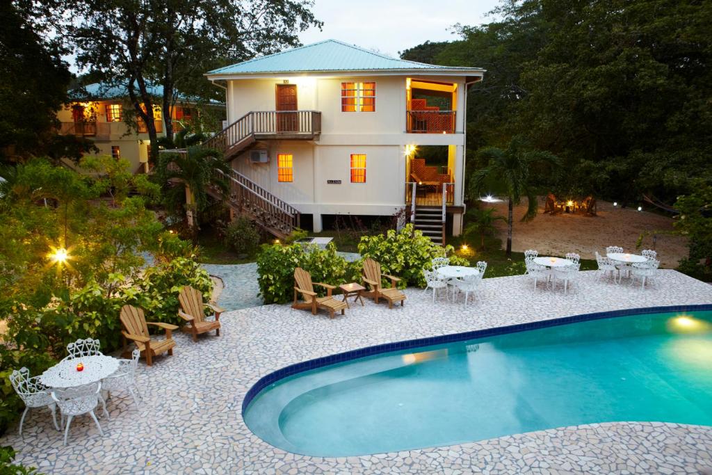 uma casa com piscina em frente a uma casa em Black Orchid Resort em Burrell Boom