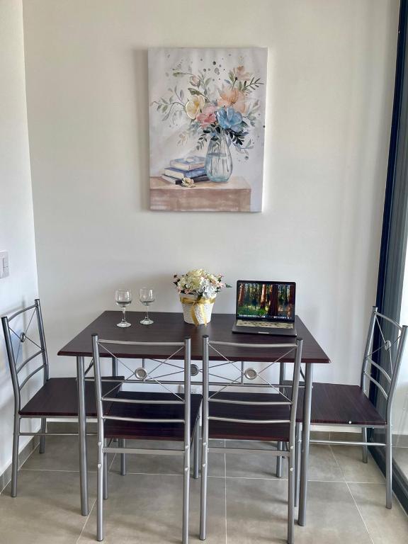 a dining room table with two chairs and a laptop on it at Tamarielys 1BR Vista a la montaña in Rodadero