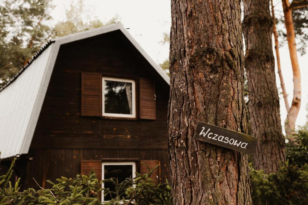 ein Schild auf einem Baum vor einem Haus in der Unterkunft Wczasowa 25 Stare Jabłonki in Stare Jabłonki
