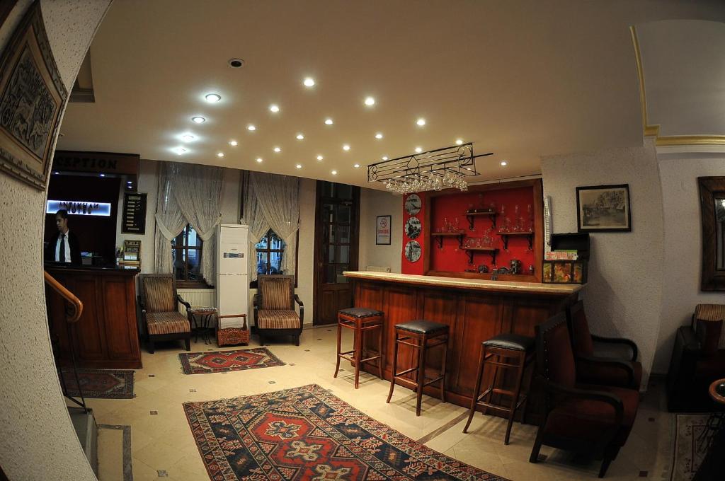 a bar in a pub with chairs and a counter at Antikhan Hotel in İzmir