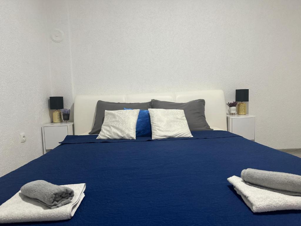a blue bed with pillows and towels on it at Holiday House As Moon in Mostar