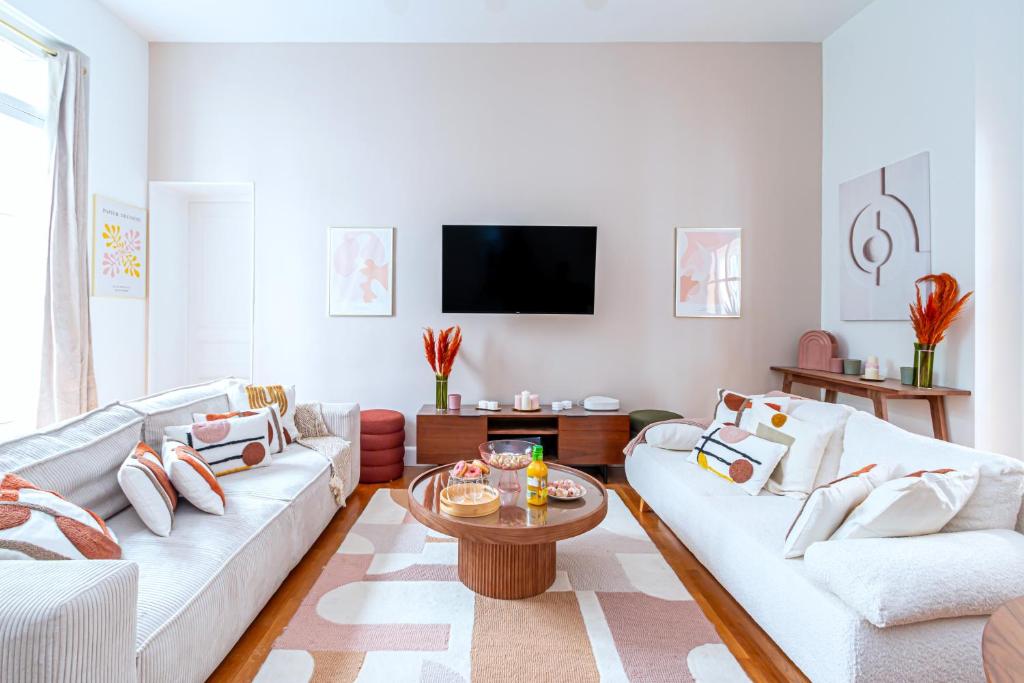 - un salon avec deux canapés blancs et une table dans l'établissement Appartement raffiné - Arc de Triomphe, à Paris
